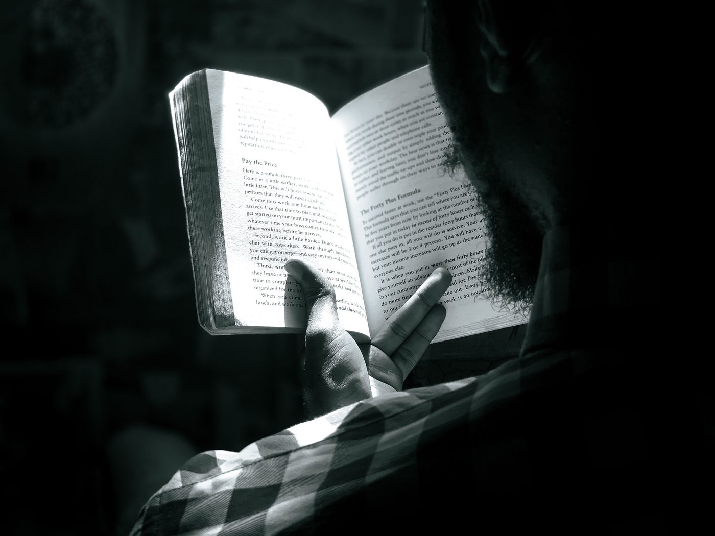 A man holding a book in black and white